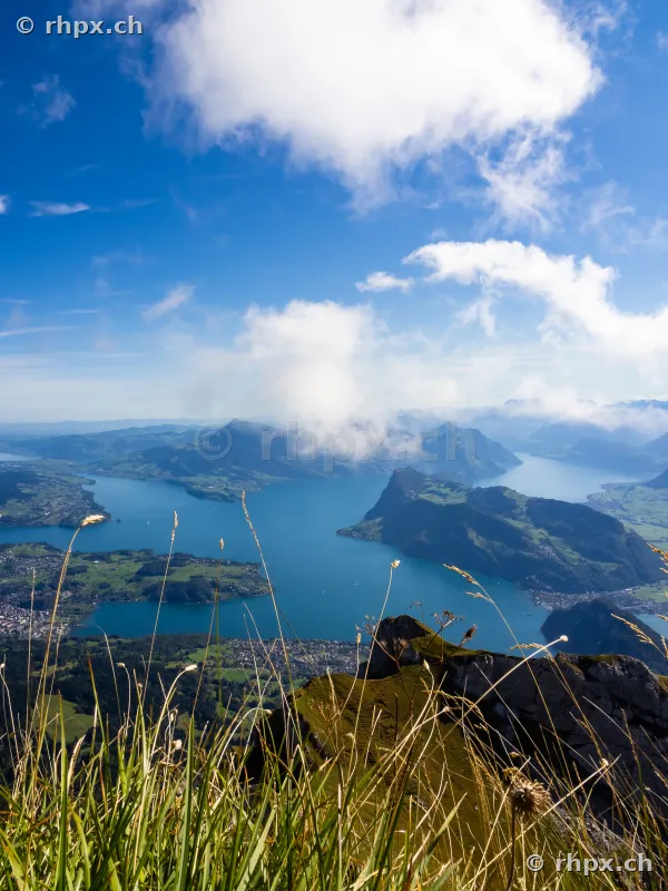 Blick vom Bergmassiv Pilatus auf den Vierwaldstättersee und umliegende Berge bei sonnigem Wetter