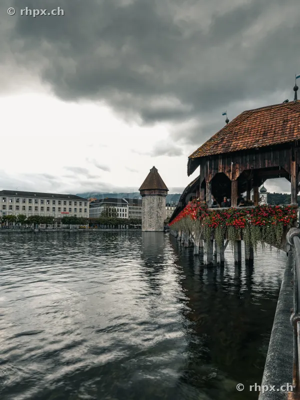 Kapellbrücke mit Wasserturm in Luzern unter bewölktem Himmel