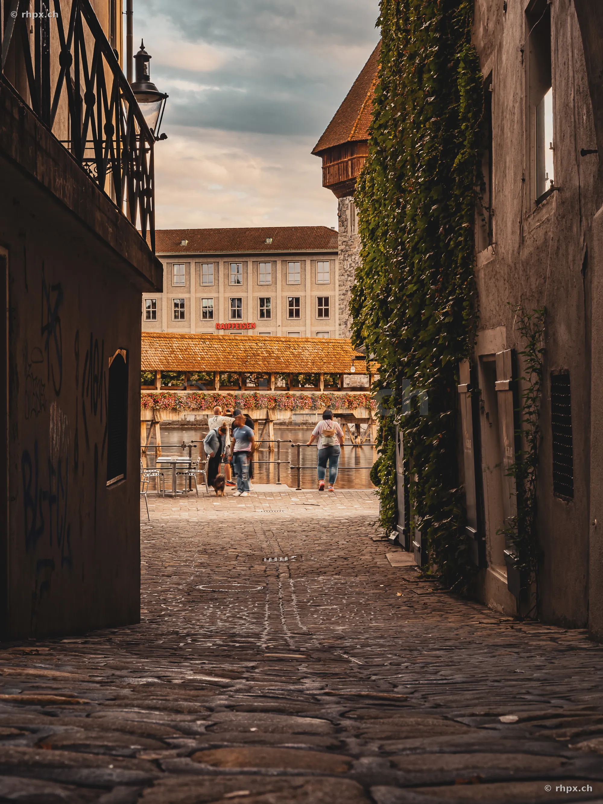 Kopfsteinpflastergasse in der Luzerner Altstadt mit Blick auf die Kapellbrücke und den Wasserturm