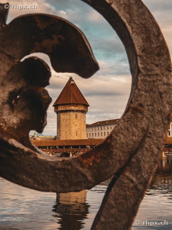 Blick auf den Wasserturm Luzern durch eine metallene Verzierung