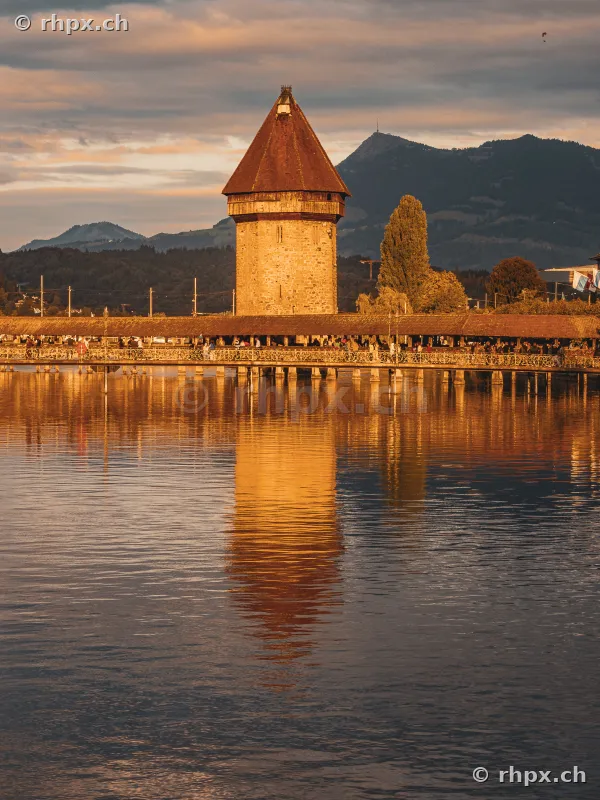 Kapellbrücke und Wasserturm in Luzern mit Spiegelung im See bei Abenddämmerung