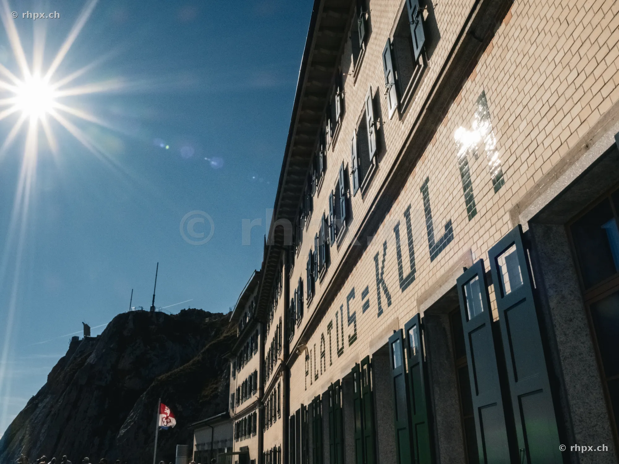 Hotel Pilatus-Kulm Fassade mit Schriftzug unter strahlender Sonne
