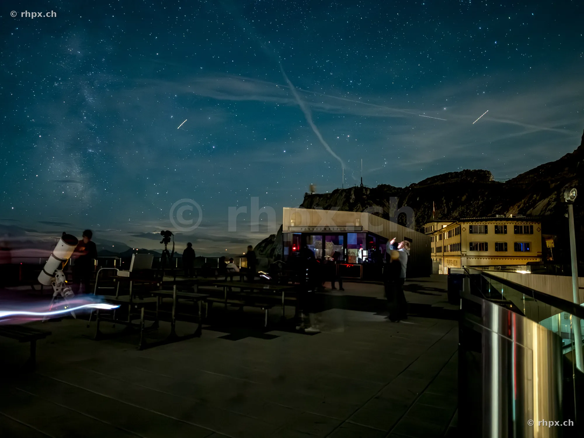 Observation deck on Pilatus Kulm at night with starry sky and telescopes