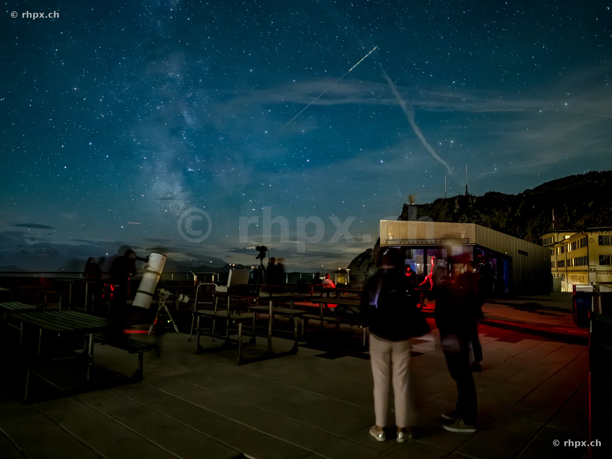 People observing the starry sky with a telescope on the observation deck at Mount Pilatus
