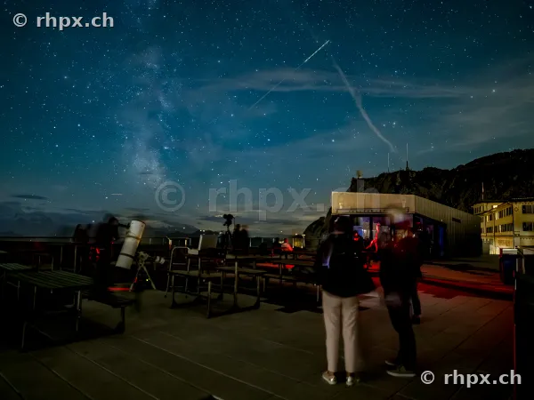 People observing the starry sky with a telescope on the observation deck at Mount Pilatus