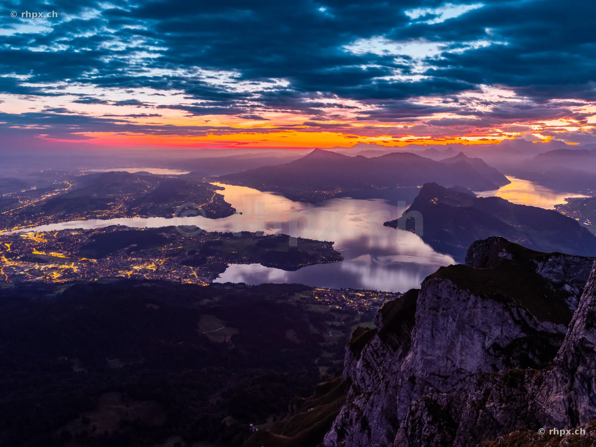 View from Mount Pilatus looking over Lake Lucerne and illuminated villages at sunset