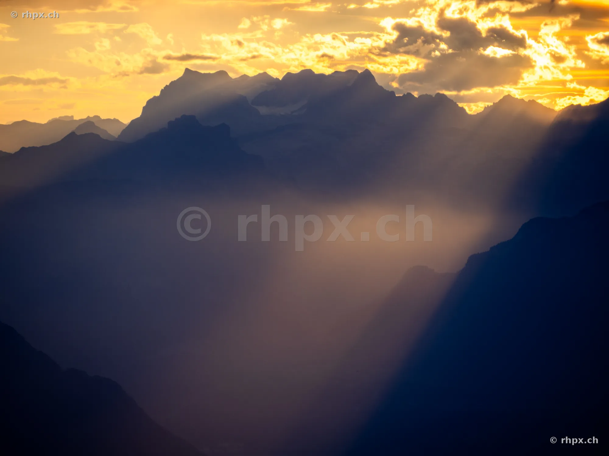 Silhouette of the Pilatus massif in evening backlight with sunbeams