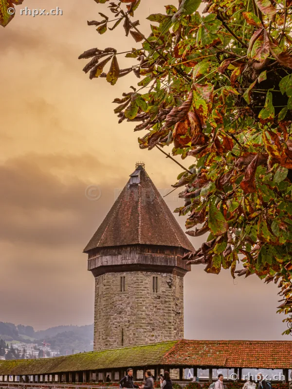 Water tower and section of the Chapel Bridge in Lucerne against an autumnal sky.