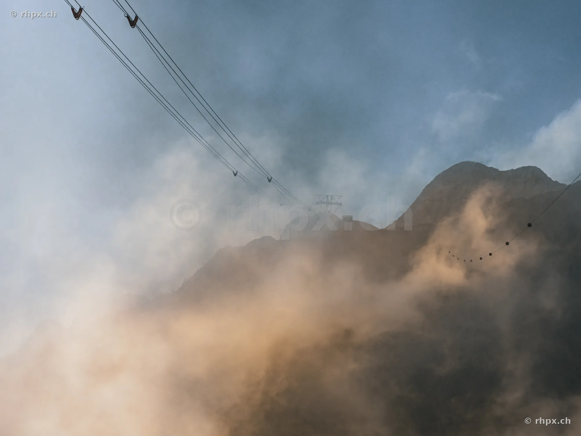 View of the cable car lines disappearing into the fog on Mount Pilatus