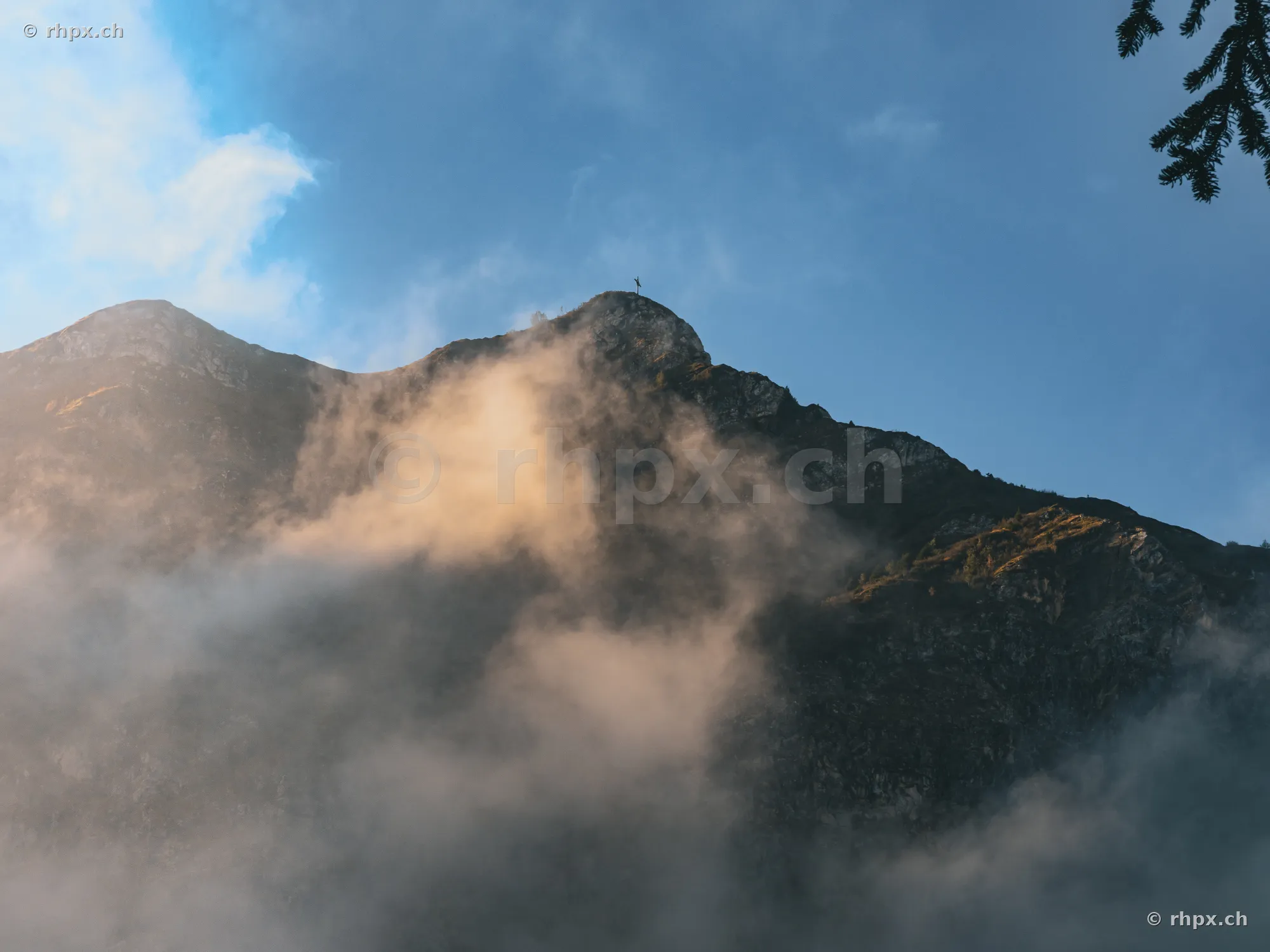 The summit of Mount Pilatus covered in mist during evening light