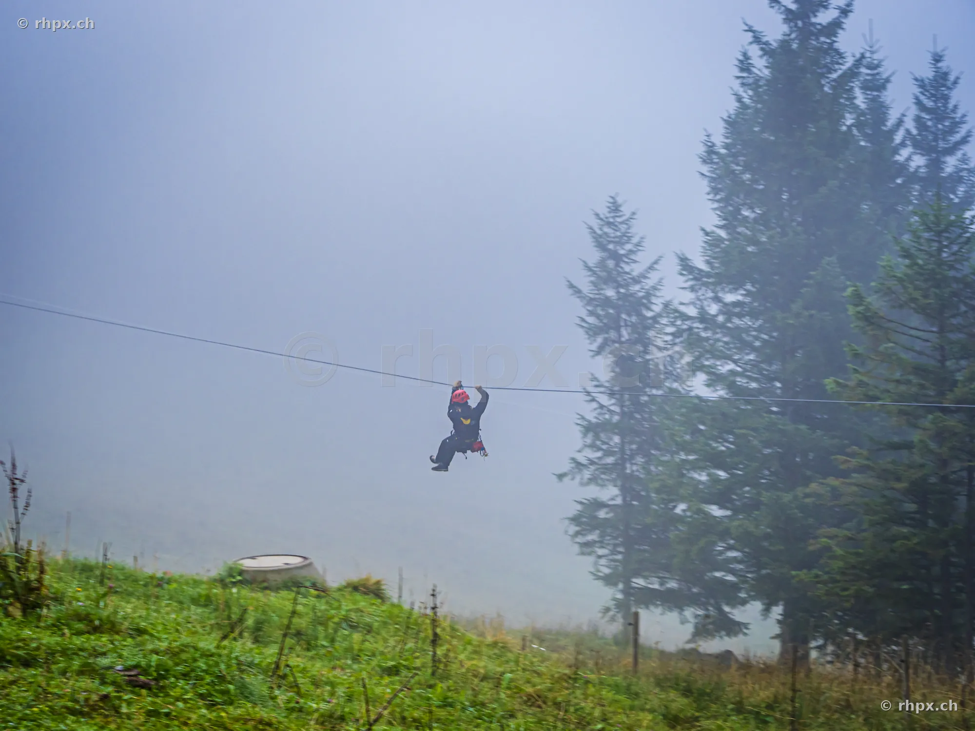 A person on a zipline in a foggy landscape at Mount Pilatus