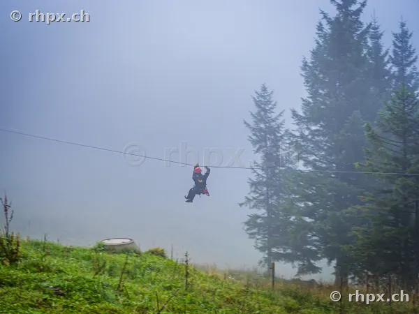A person on a zipline in a foggy landscape at Mount Pilatus