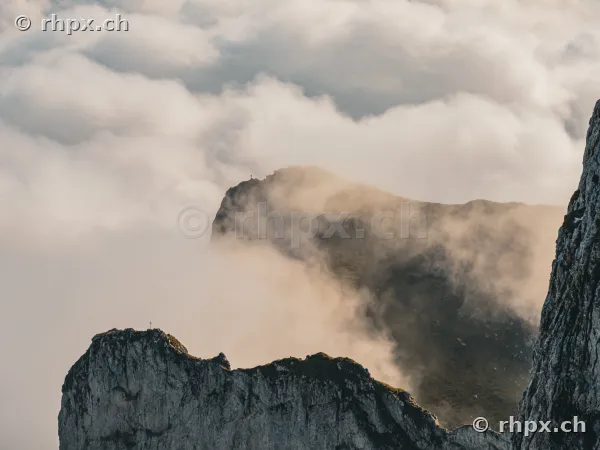 View of the rugged rocks of Mount Pilatus emerging from a dense cloud cover.