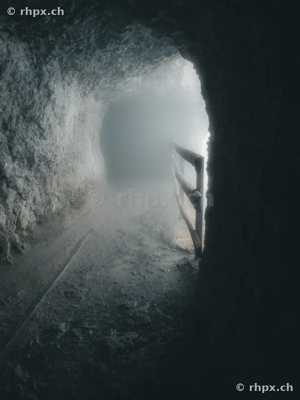Rocky path in the Dragon Cave on Mount Pilatus with dense fog