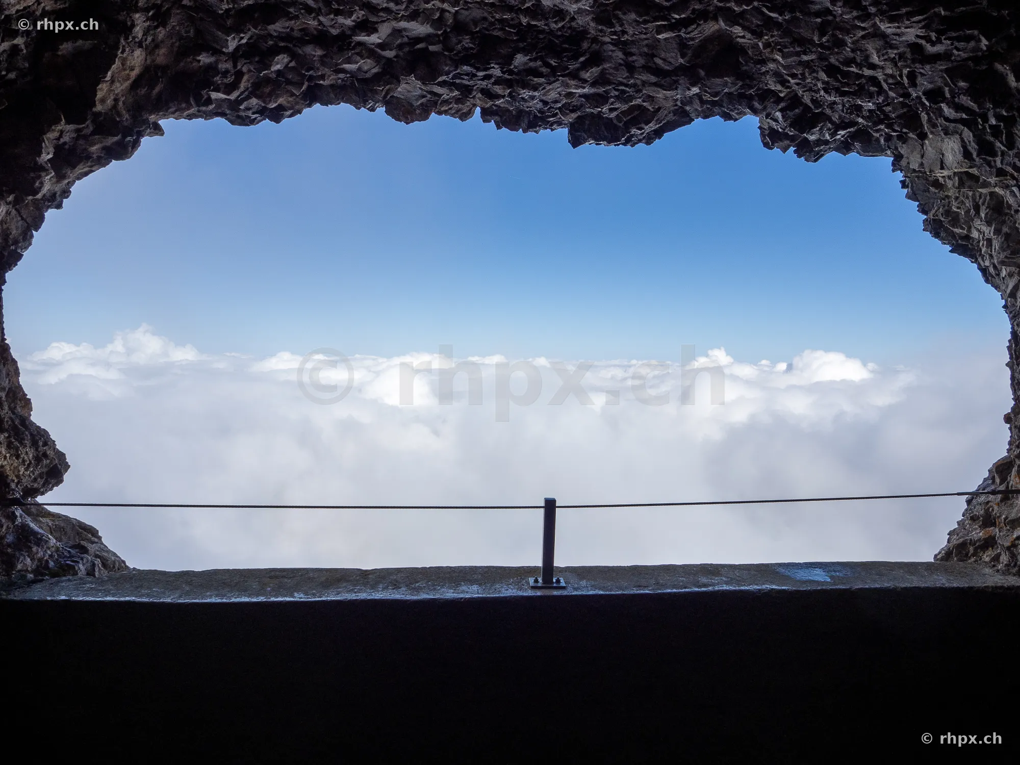 View from a rock opening at Mount Pilatus over a sea of clouds