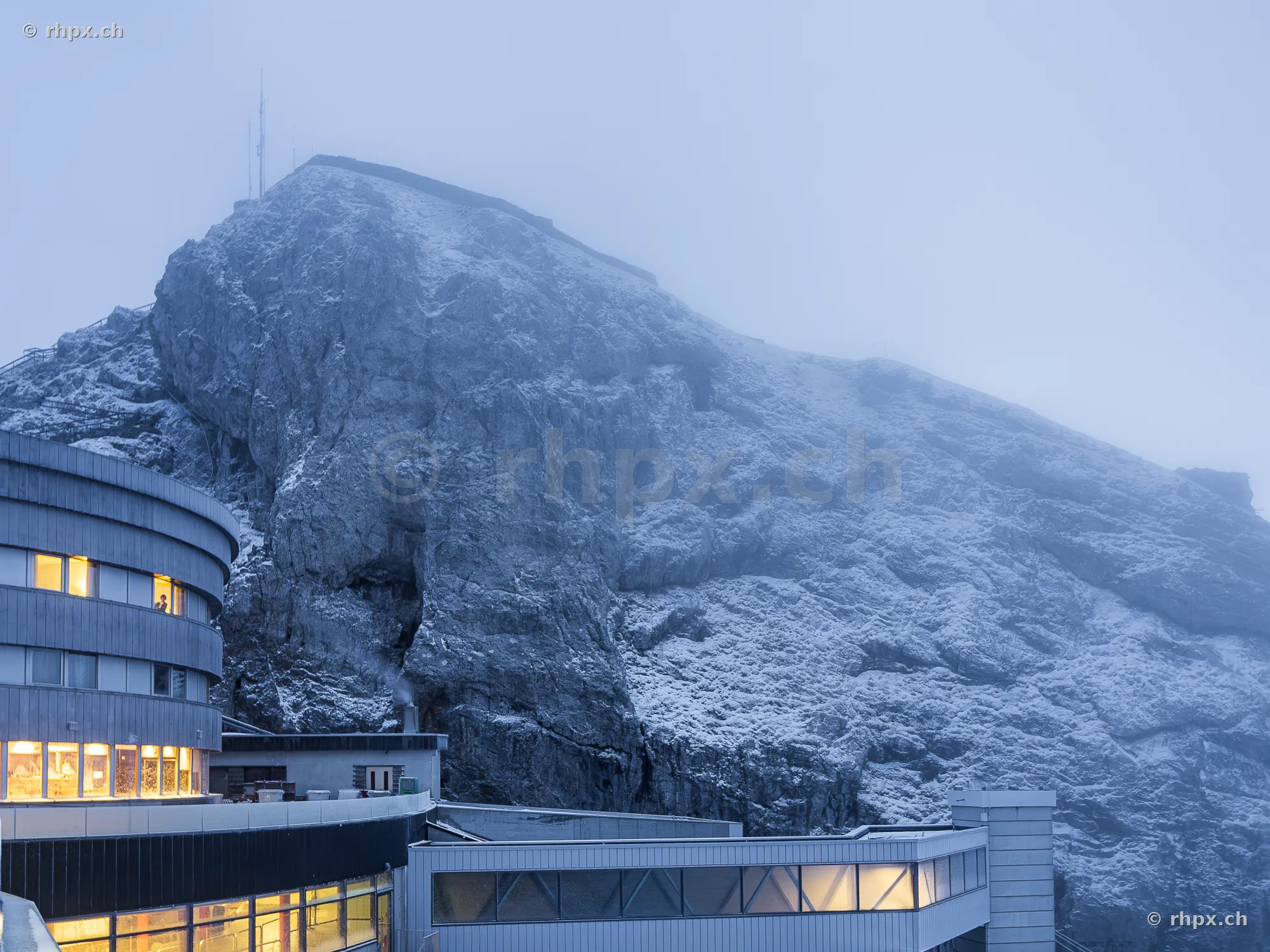 Blick auf das Hotel Bellevue und die verschneiten Felswände des Pilatus bei nebligem Wetter