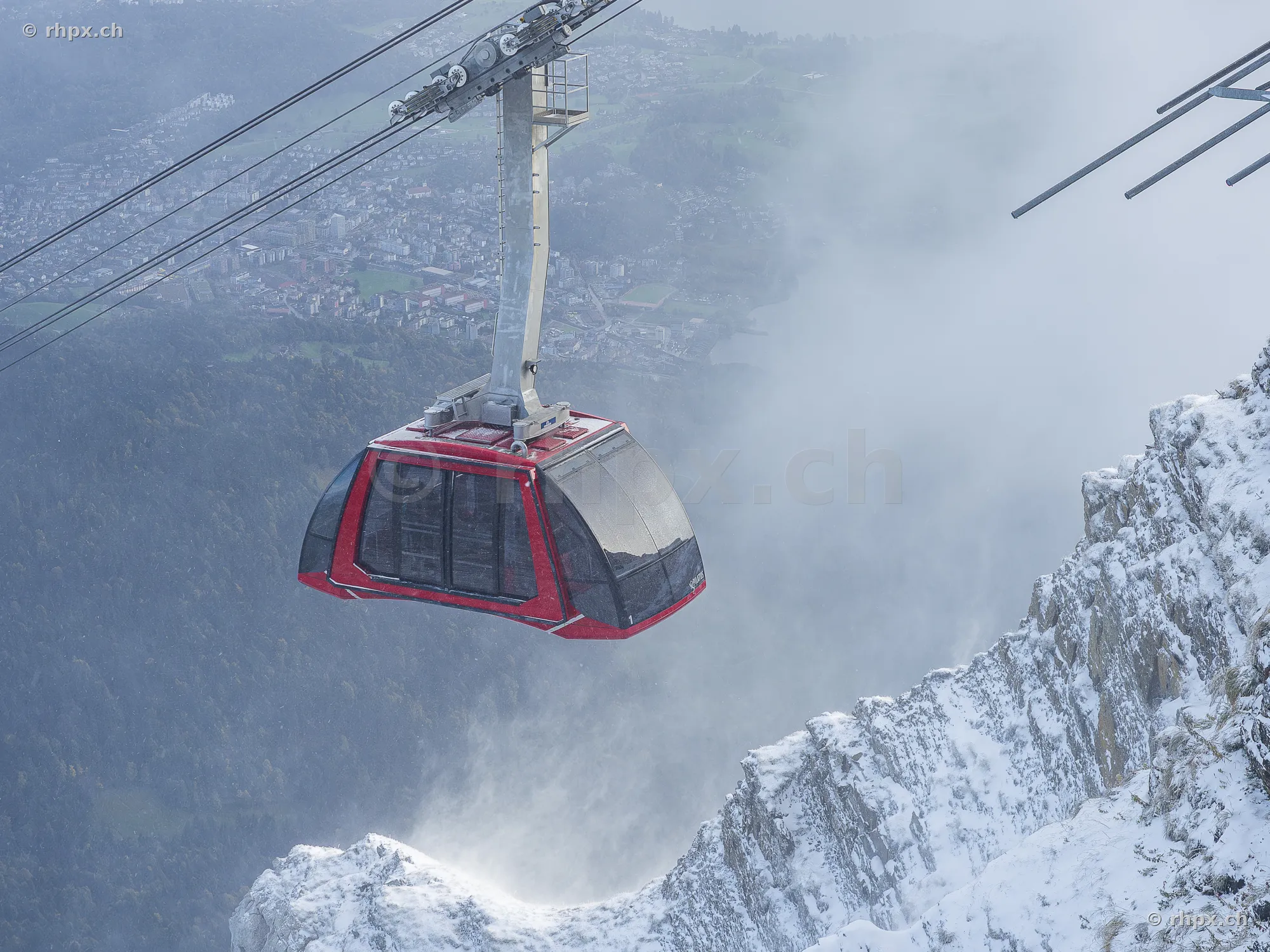 Red aerial cable car at Mount Pilatus in a misty mountain landscape