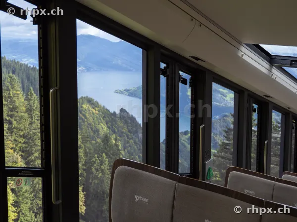 Blick aus dem Fenster der Pilatusbahn auf den Vierwaldstättersee und bewaldete Hänge