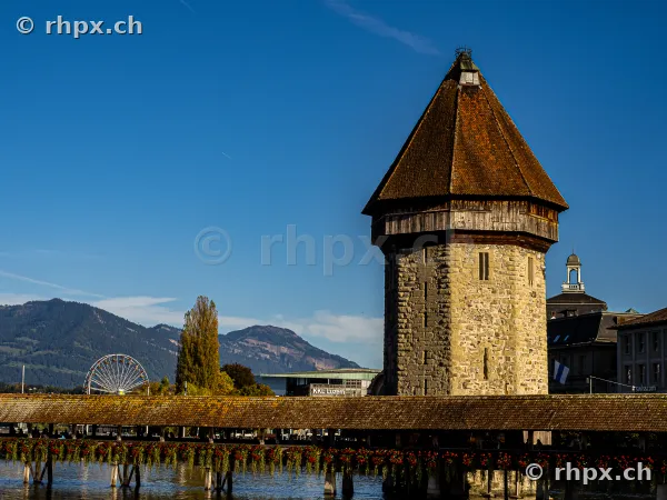 Wasserturm and part of the Chapel Bridge in Lucerne with a mountain range in the background