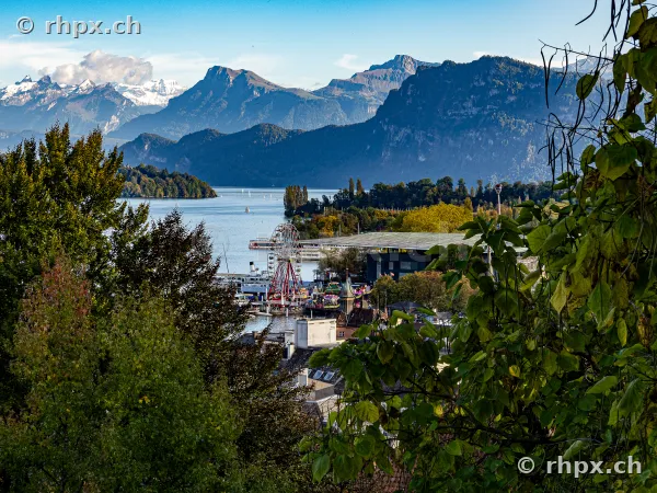 View of Lake Lucerne with a ferris wheel in front of Mount Pilatus and the Alps