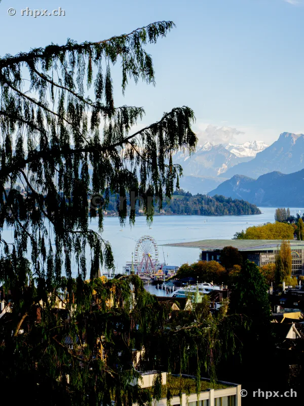 View of the Ferris wheel, KKL Lucerne and Lake Lucerne with the Alps in the background