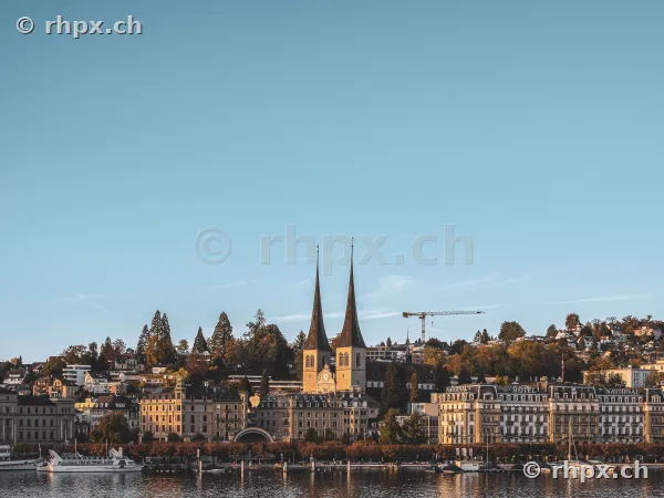Blick über den Vierwaldstättersee auf die Luzerner Hofkirche bei Sonnenlicht