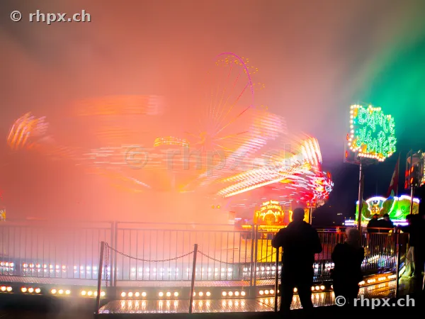 A motion-blurred chain carousel at night at a funfair in Lucerne.