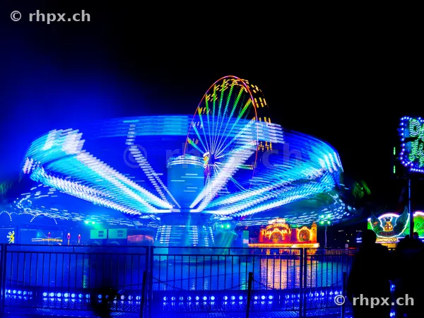 Illuminated chain carousel in motion at night