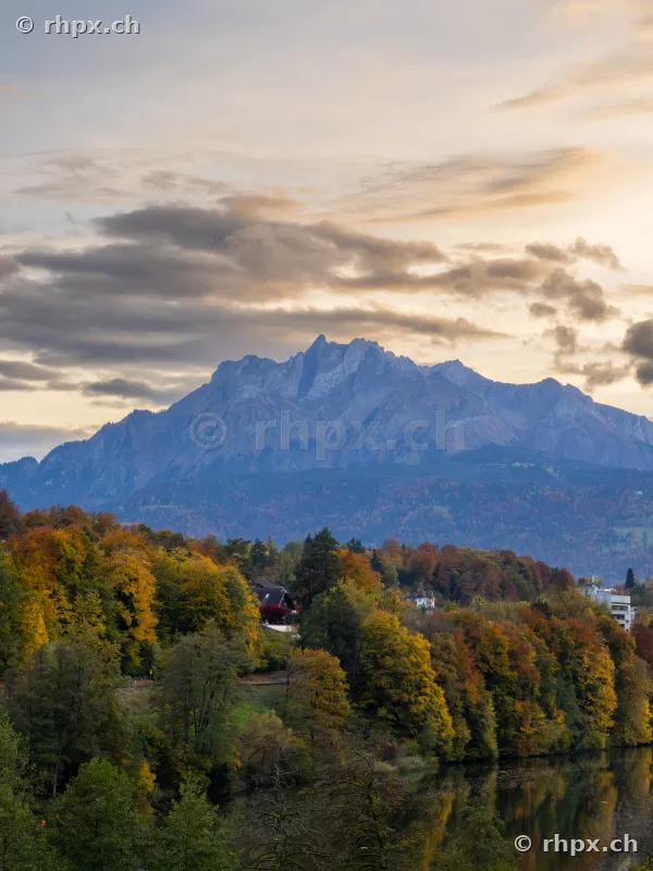 Autumn forest with Mount Pilatus in the background under a cloudy evening sky