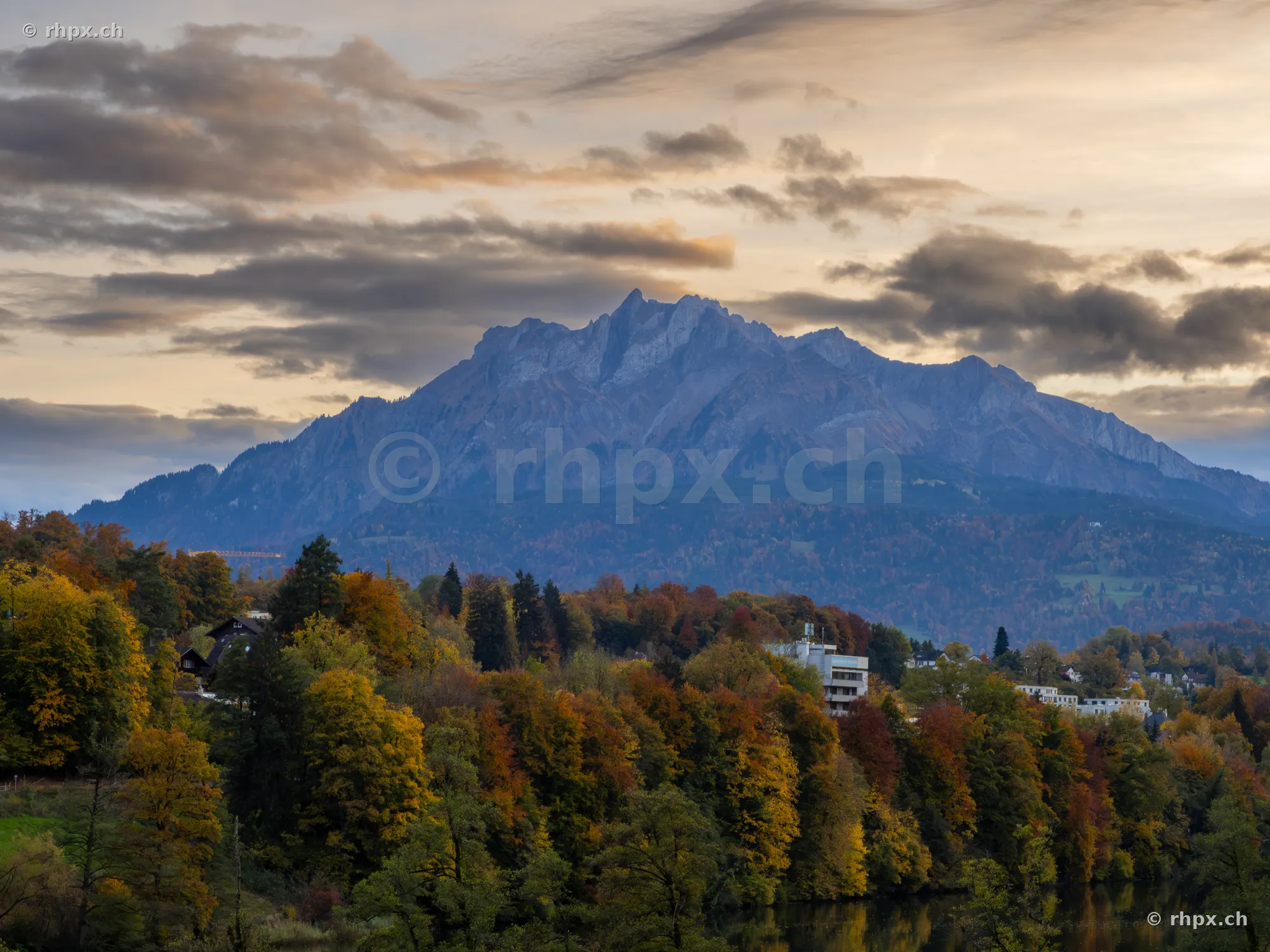 Mount Pilatus above an autumn colored forest at dusk