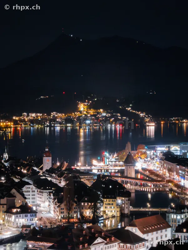 Nächtliche Ansicht der Stadt Luzern mit Kapellbrücke und Pilatus im Hintergrund