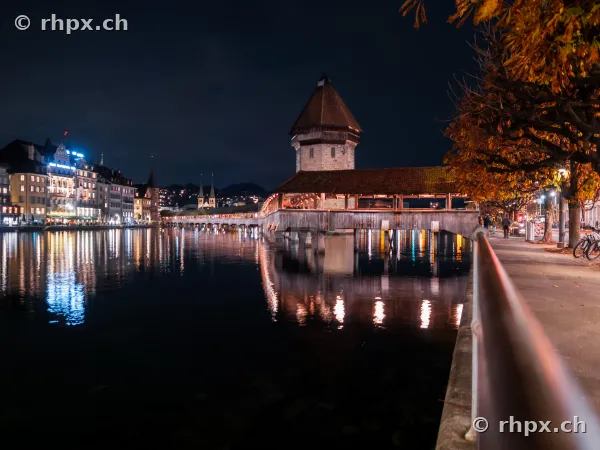 Nachtaufnahme der Kapellbrücke mit Wasserturm in Luzern am Ufer der Reuss
