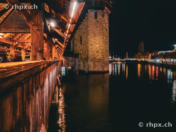 Ansicht der beleuchteten Kapellbrücke mit Wasserturm in Luzern bei Nacht