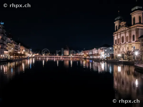 Nächtliche Ansicht der Jesuitenkirche am Ufer der Reuss in Luzern mit Reflexionen im Wasser