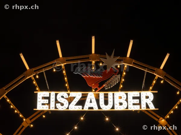 Illuminated Eiszauber sign with star motif at night in Lucerne