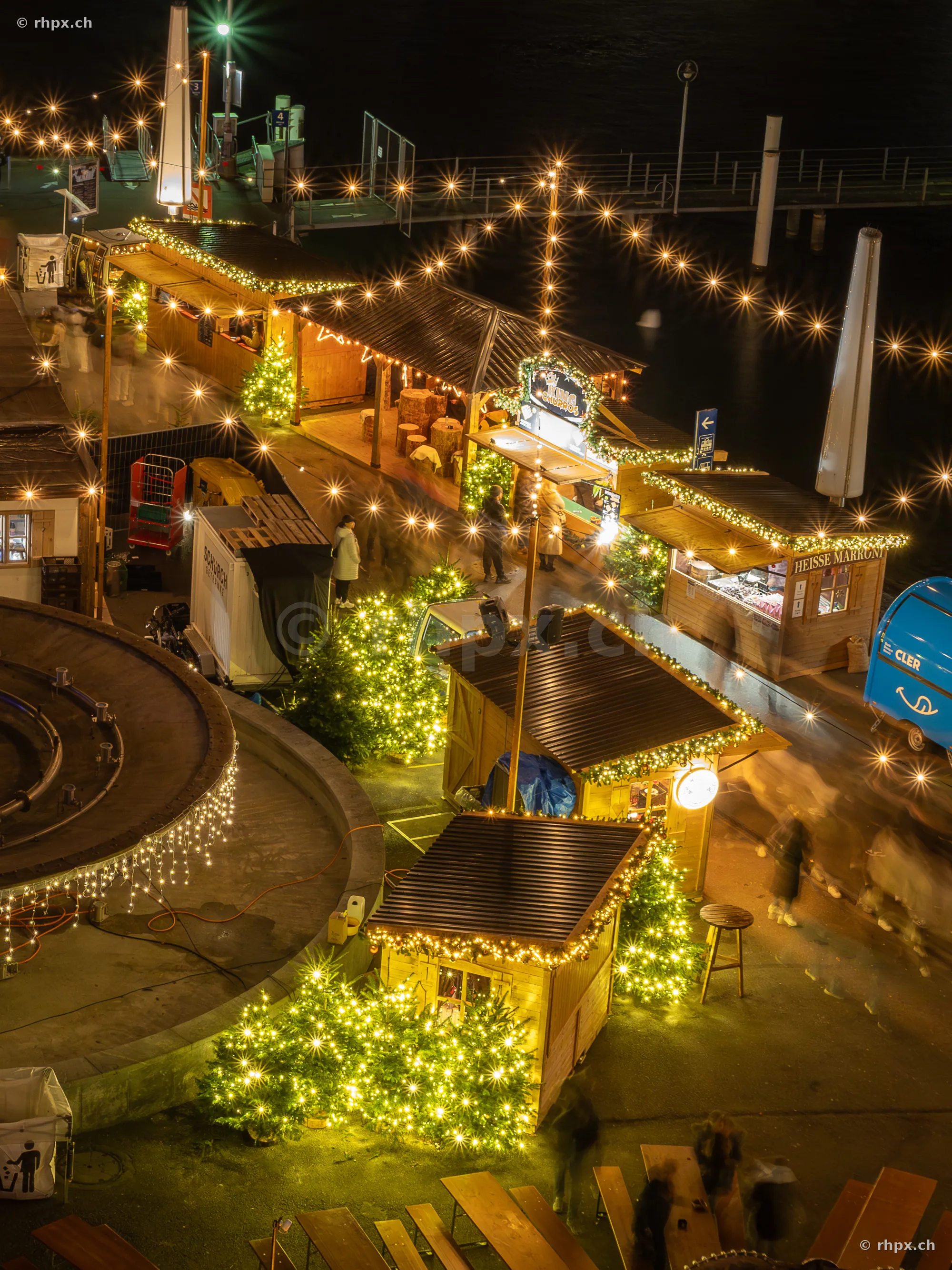 Nächtliche Ansicht des Weihnachtsmarktes am Luzerner Seebecken mit beleuchteten Marktständen und Tannenbäumen