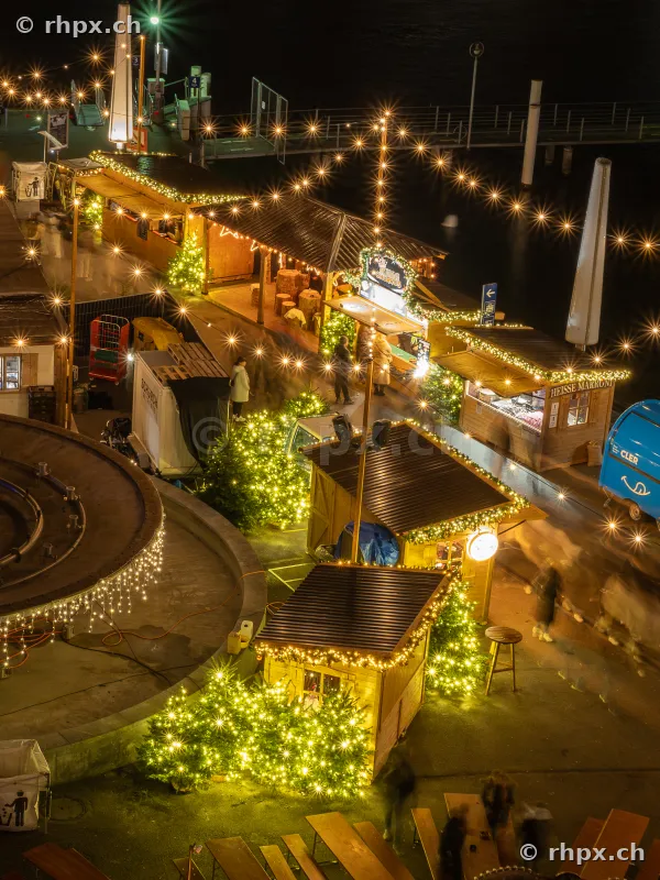 Night view of the Christmas market at the Lake Lucerne waterfront with illuminated stalls and Christmas trees