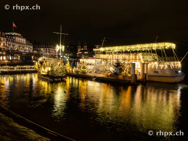 Festlich beleuchtetes Passagierschiff am Luzerner Quai bei Nacht mit Spiegelung im Vierwaldstättersee