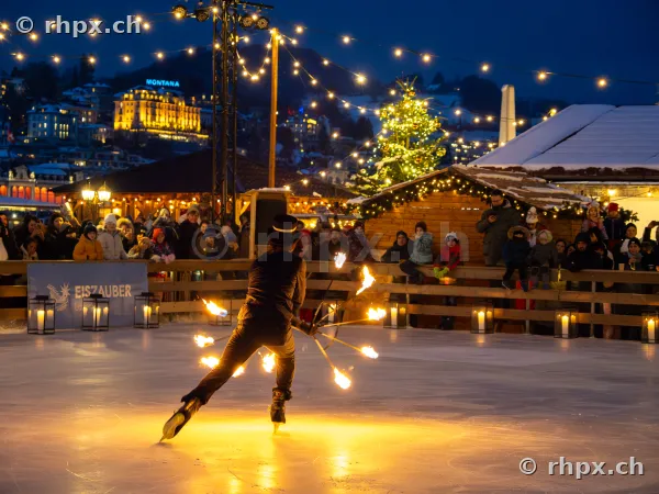 A performer presents a fire show on the ice rink at Eiszauber Lucerne