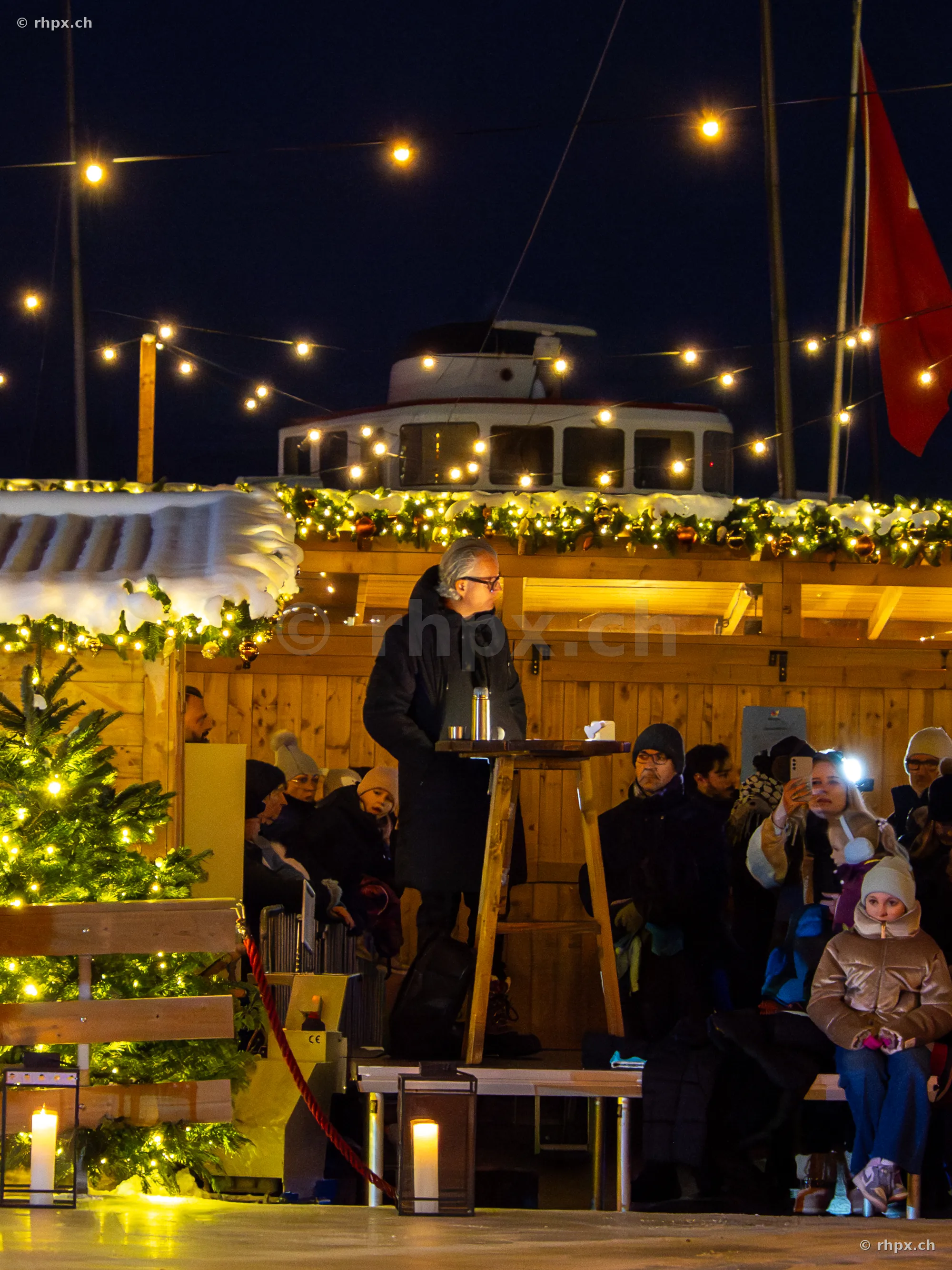 Christmas market stall at the Lucerne waterfront with people at night