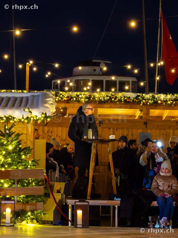 Christmas market stall at the Lucerne waterfront with people at night