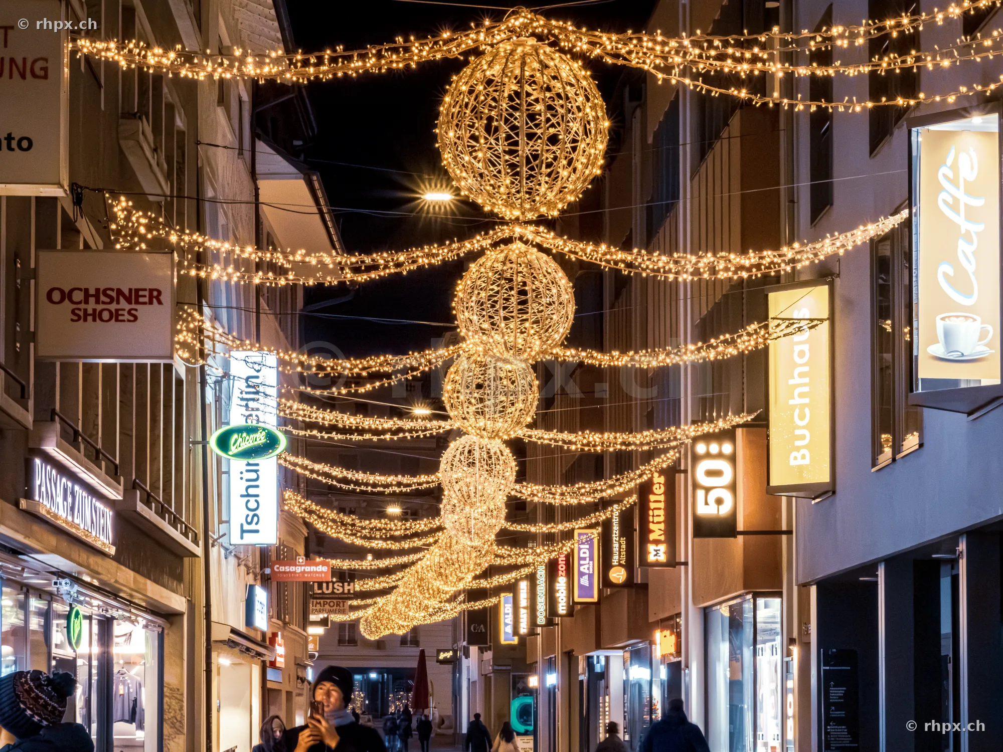 Weihnachtsbeleuchtung mit leuchtenden Kugeln in einer Strasse in Luzern bei Nacht