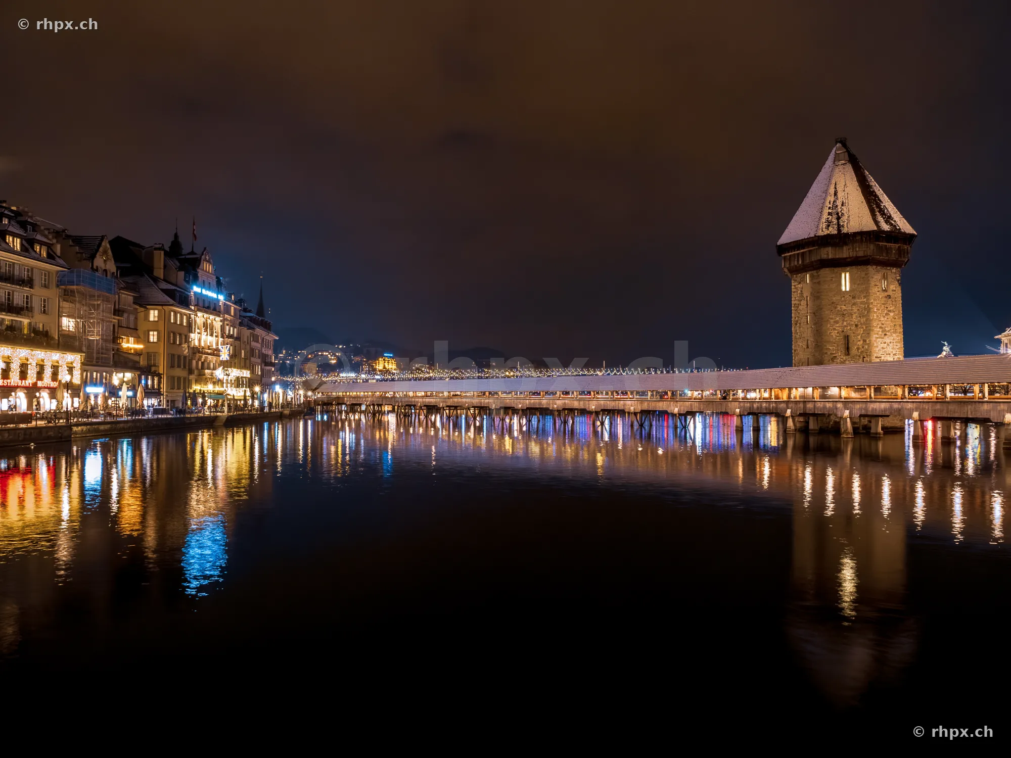 Chapel Bridge and Water Tower in Lucerne at night during winter with festive lights
