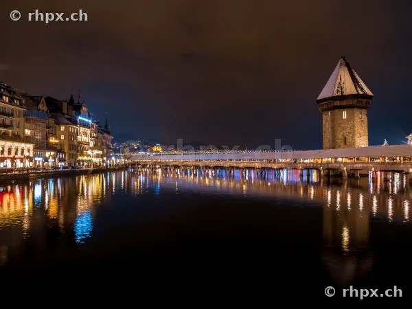 Chapel Bridge and Water Tower in Lucerne at night during winter with festive lights