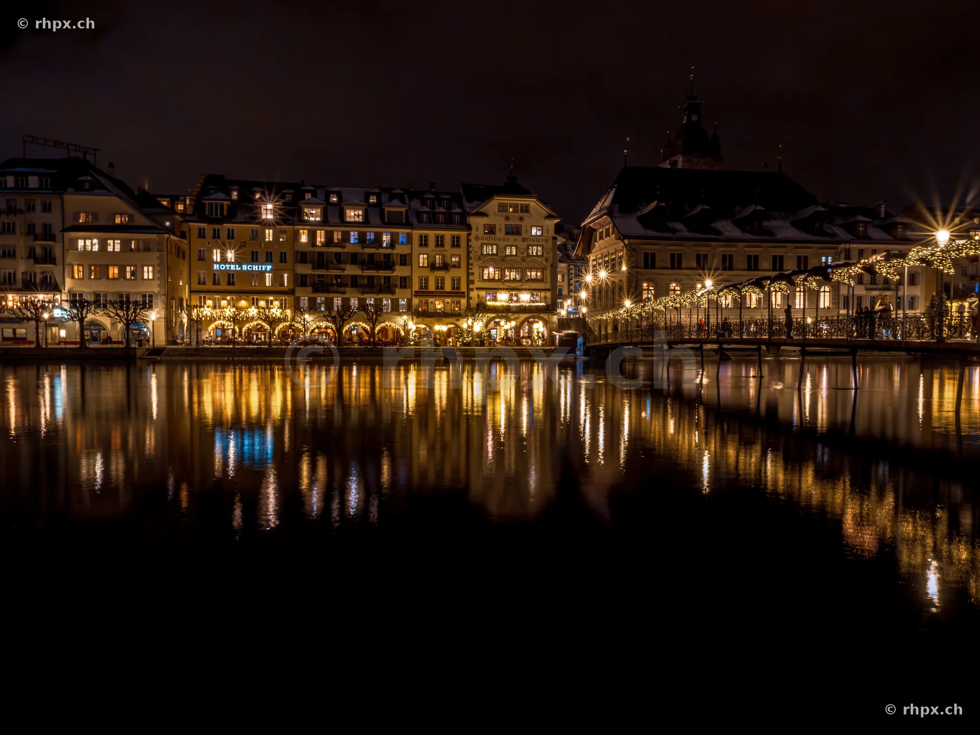 Night view of the Christmas-lit buildings along the Reuss river in Lucerne