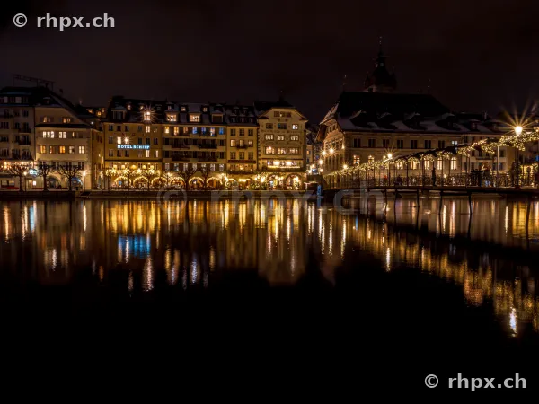 Night view of the Christmas-lit buildings along the Reuss river in Lucerne