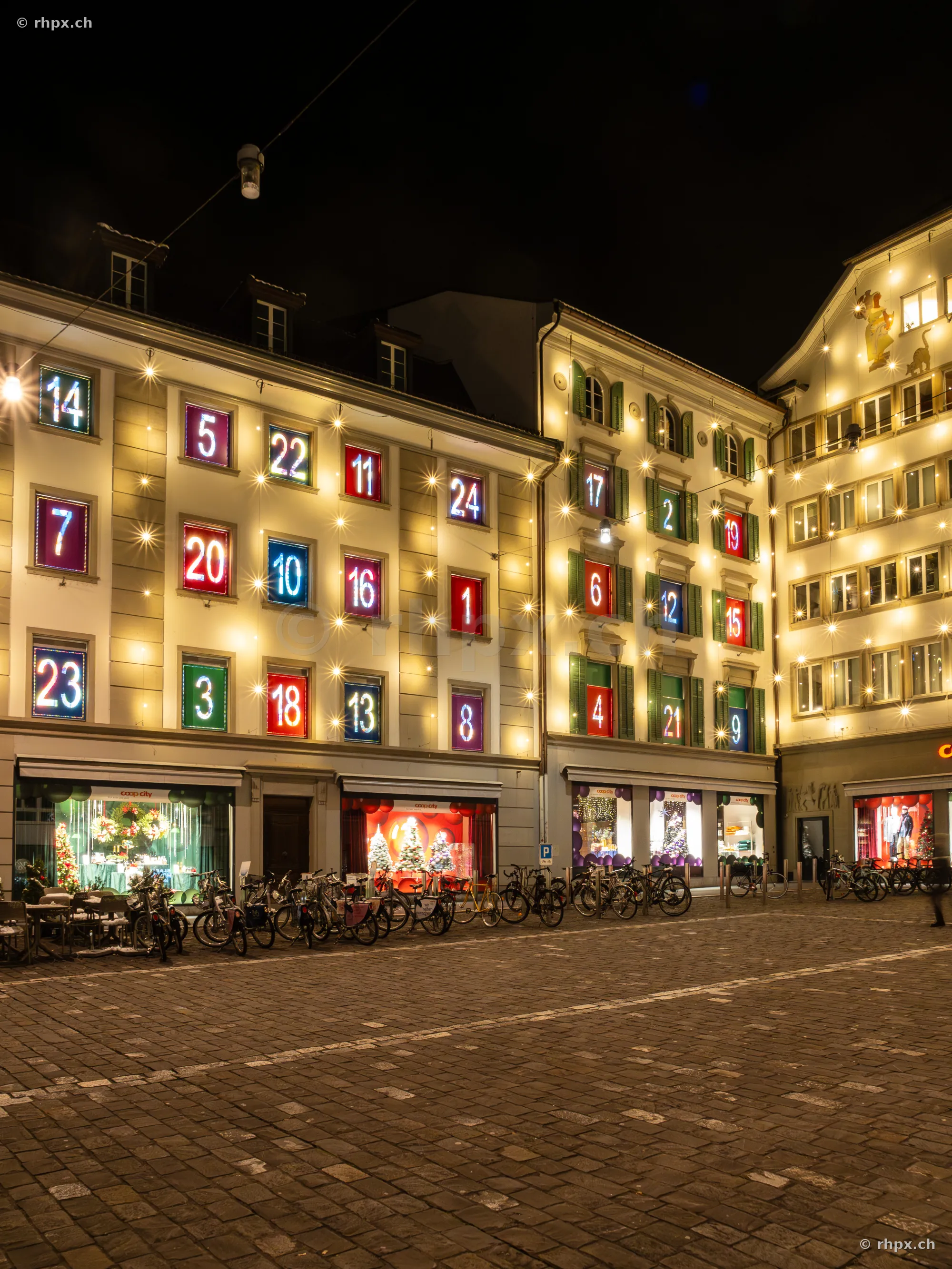 Building facade in Lucerne decorated as a large advent calendar with illuminated numbers.