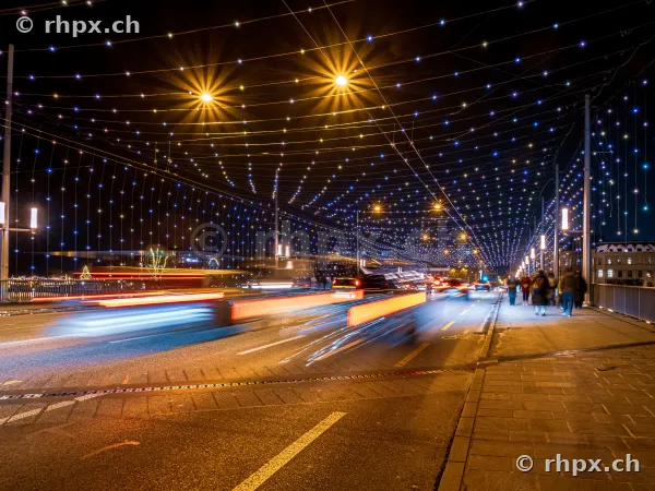 Light installation over the night-time Seebrücke in Lucerne with moving vehicles