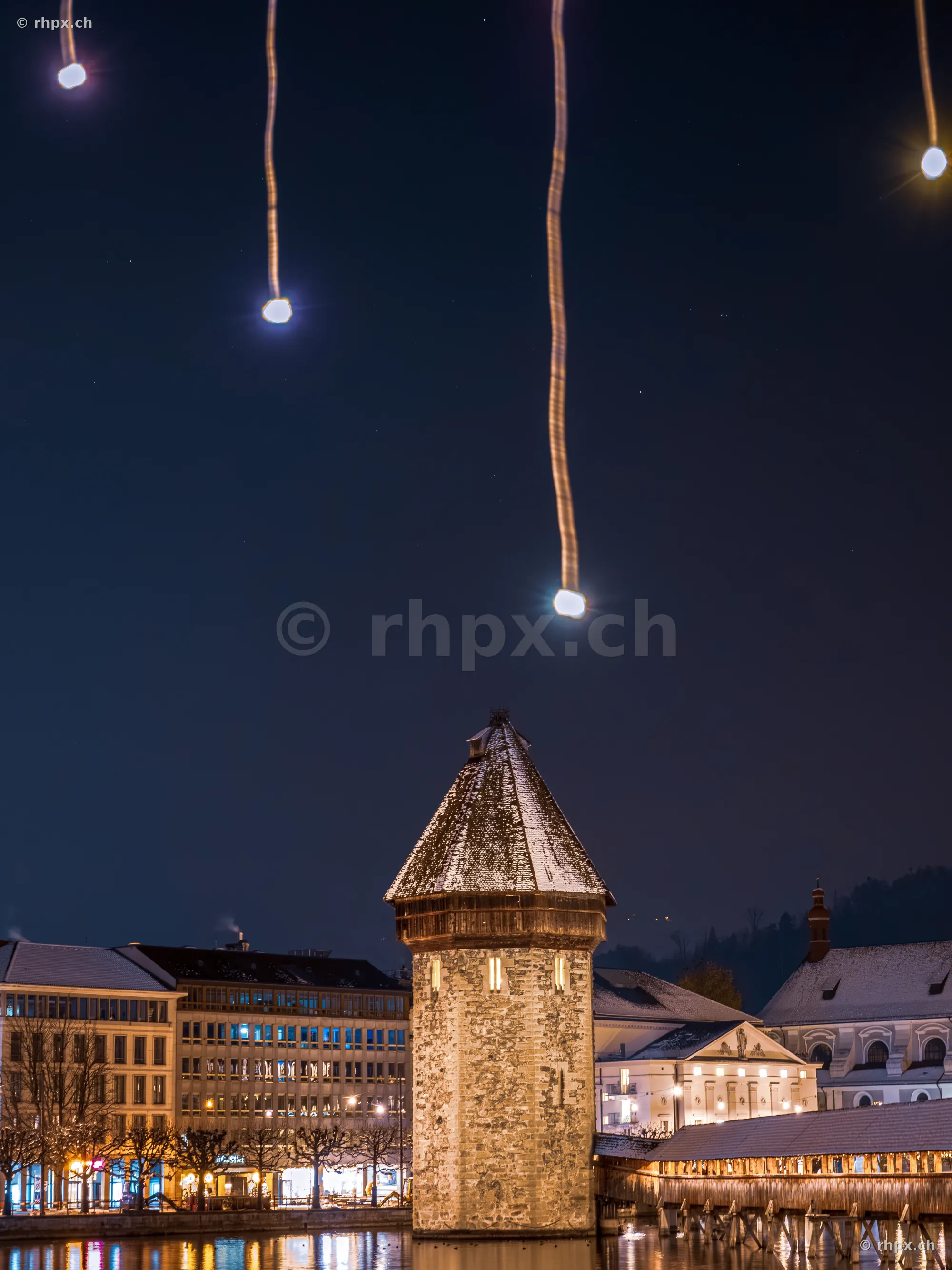 Water tower of the Chapel Bridge in Lucerne with nightly Christmas lighting