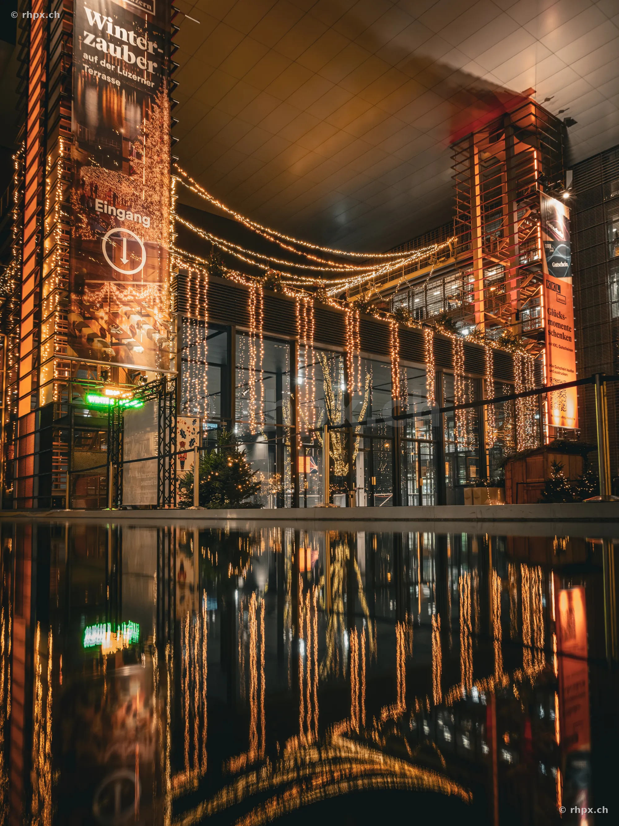 Beleuchtete Fassade des KKL Luzern in der Weihnachtszeit mit Spiegelung